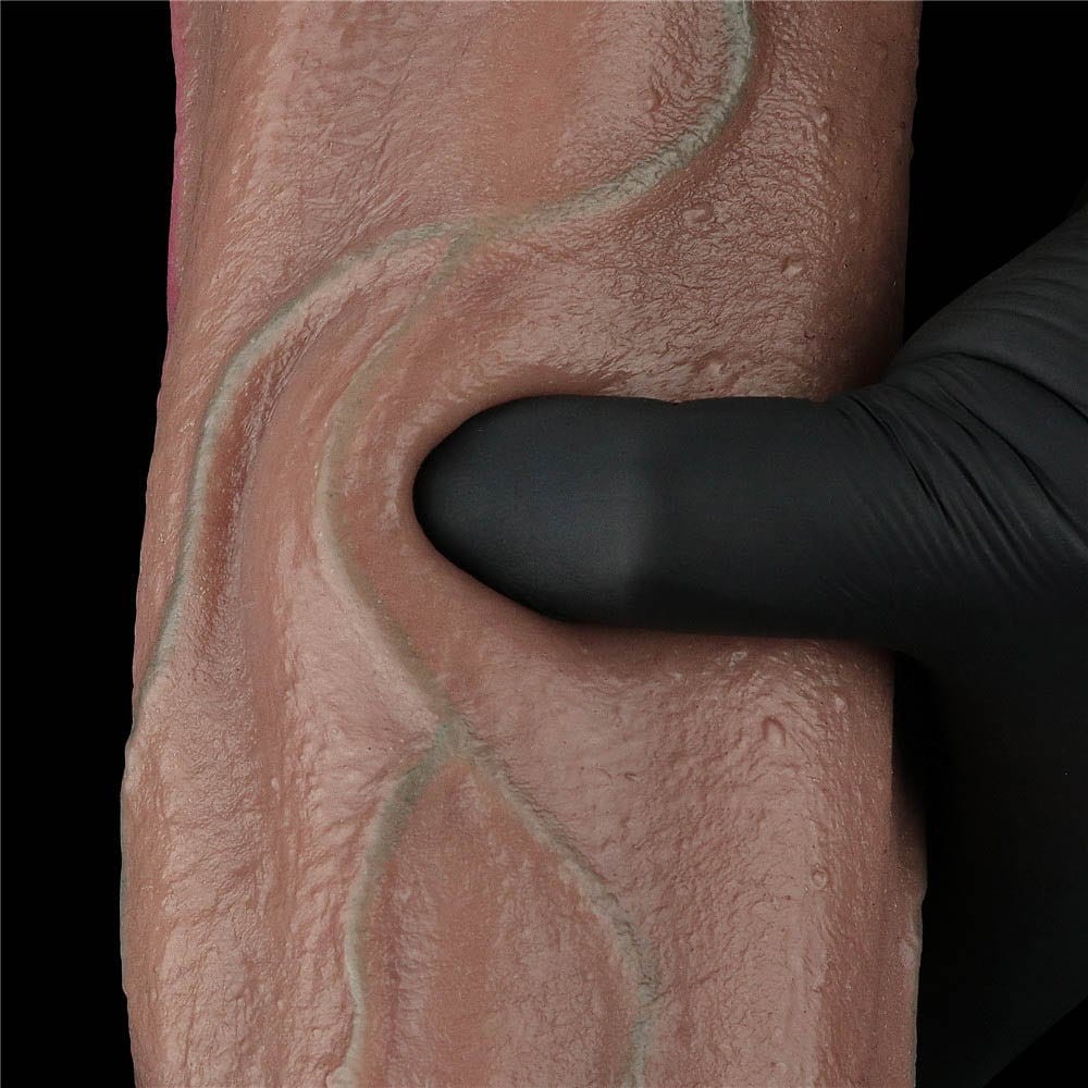 Deget apasat in tija dildo-ului Nature Cock 13 inch, aratand cedarea controlata a materialului dual-layer