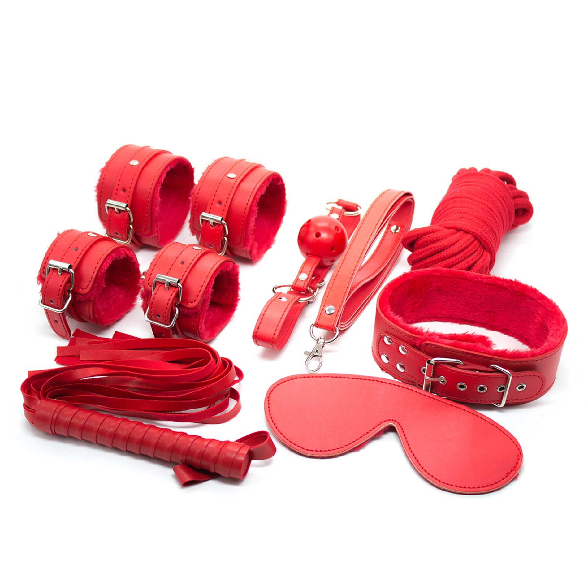 Toate cele 8 piese ale setului BDSM rosu asezate impreuna: catuse, zgarda, calus, bici, masca, franghie