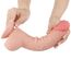 Dildo-ul Lovetoy Sliding Skin 9.5 inch curbat, cu pielea culisanta trasa simultan, demonstrand flexibilitatea totala