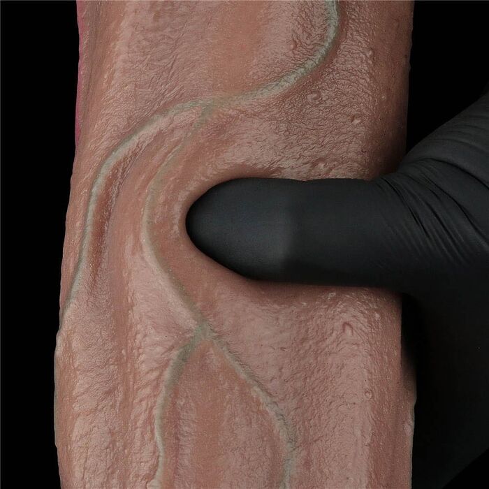 Deget apasat in tija dildo-ului Nature Cock 13 inch, aratand cedarea controlata a materialului dual-layer