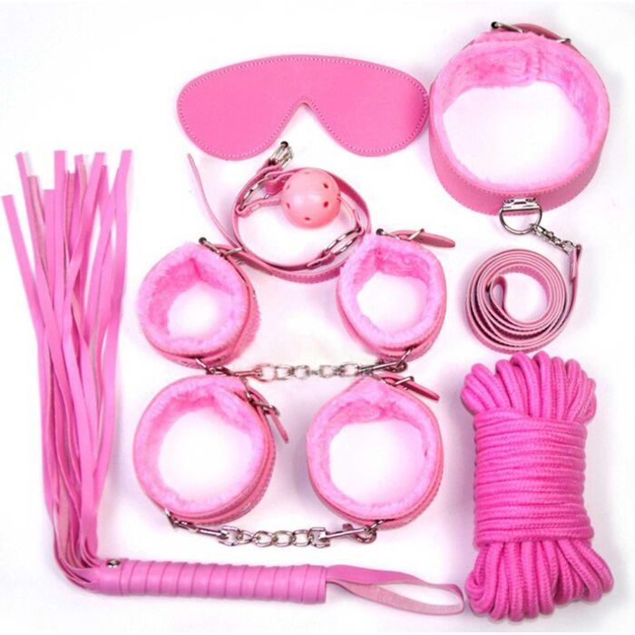 Cele 7 piese ale kitului BDSM Fetish B-Series roz, asezate individual: catuse maini, catuse picioare, zgarda cu lesa, minge cu chinga, bici, masca pentru ochi, franghie